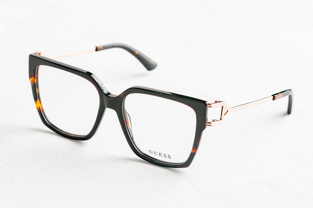 Close-up of fashionable Guess eyeglasses with tortoiseshell frame on white background.